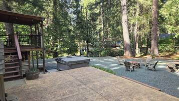 Une terrasse avec coin salon extérieur, un jacuzzi et un espace recouvert de gravier.