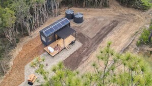 Eine abgelegene Holzhütte mit Solaranlage, umgeben von dichtem Wald.