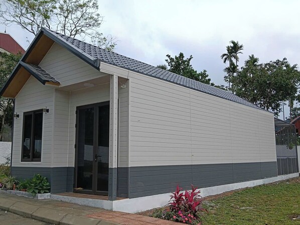 A single-story building with a flat roof, a front door, and a small porch area.