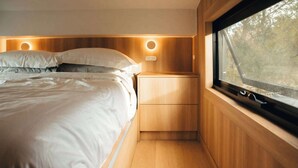 Een slaapkamer met een bed, nachtkastjes en een raam.