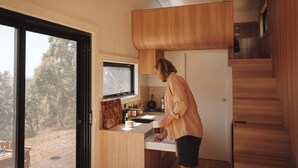 Een moderne keuken met een houten aanrecht, een raam en uitzicht op de omgeving.