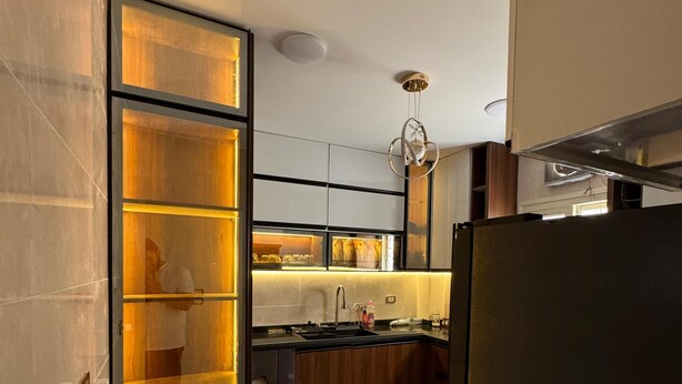 Una cocina moderna con horno empotrado, un lavamanos y una encimera.