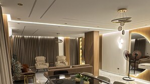 Un comedor moderno con una mesa de mármol, sillas tapizadas e iluminación empotrada en el techo.