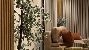 Una sala moderna con un sofá, una mesa redonda y una planta en maceta.