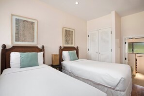 A hotel room with two beds, a wardrobe, and two framed pictures on the wall. - Kapalua Ridge | Ocean View 5 BR, Sleeps 14 | Car Incl. w/ 6+ Nights | KRV ML-3948 by KBM (Lahaina)