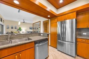 Una cocina moderna con armarios de madera, electrodomésticos de acero inoxidable y encimera de granito.