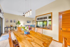 Un comedor amplio con una mesa de madera, bancos y un ventanal grande.
