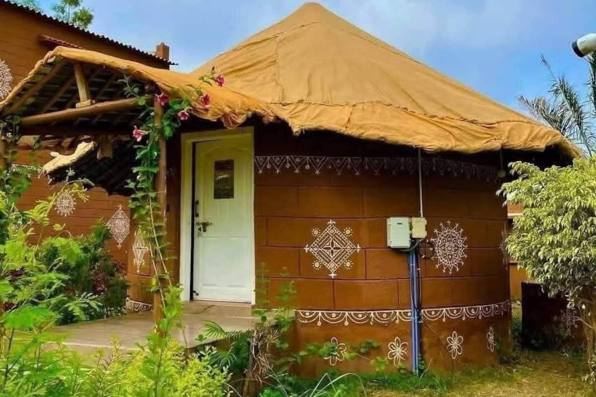 A rustic house with a thatched roof, a wooden door, and decorative patterns on the walls.
