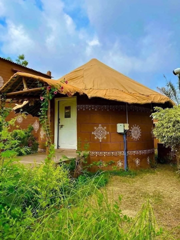 A rustic house with a thatched roof, a wooden door, and decorative patterns on the walls.