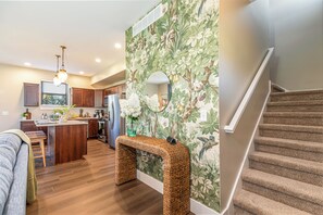 A kitchen with wooden cabinets, a central island, and a staircase. - Brand New Home! Hot Tub Massage Chair Game Room, Dog Friendly, Fun for all ages! (Galena)