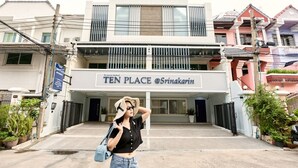 A building with a sign reading 'TEN PLACE @Srinakarin' and a person standing in front. - TEN-Place Srinakarin (Bangkok)