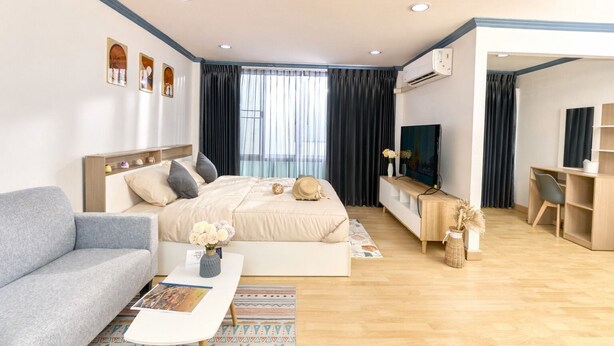 A modern hotel room with a bed, a sofa, a desk, and a TV. - TEN-Place Srinakarin (Bangkok)