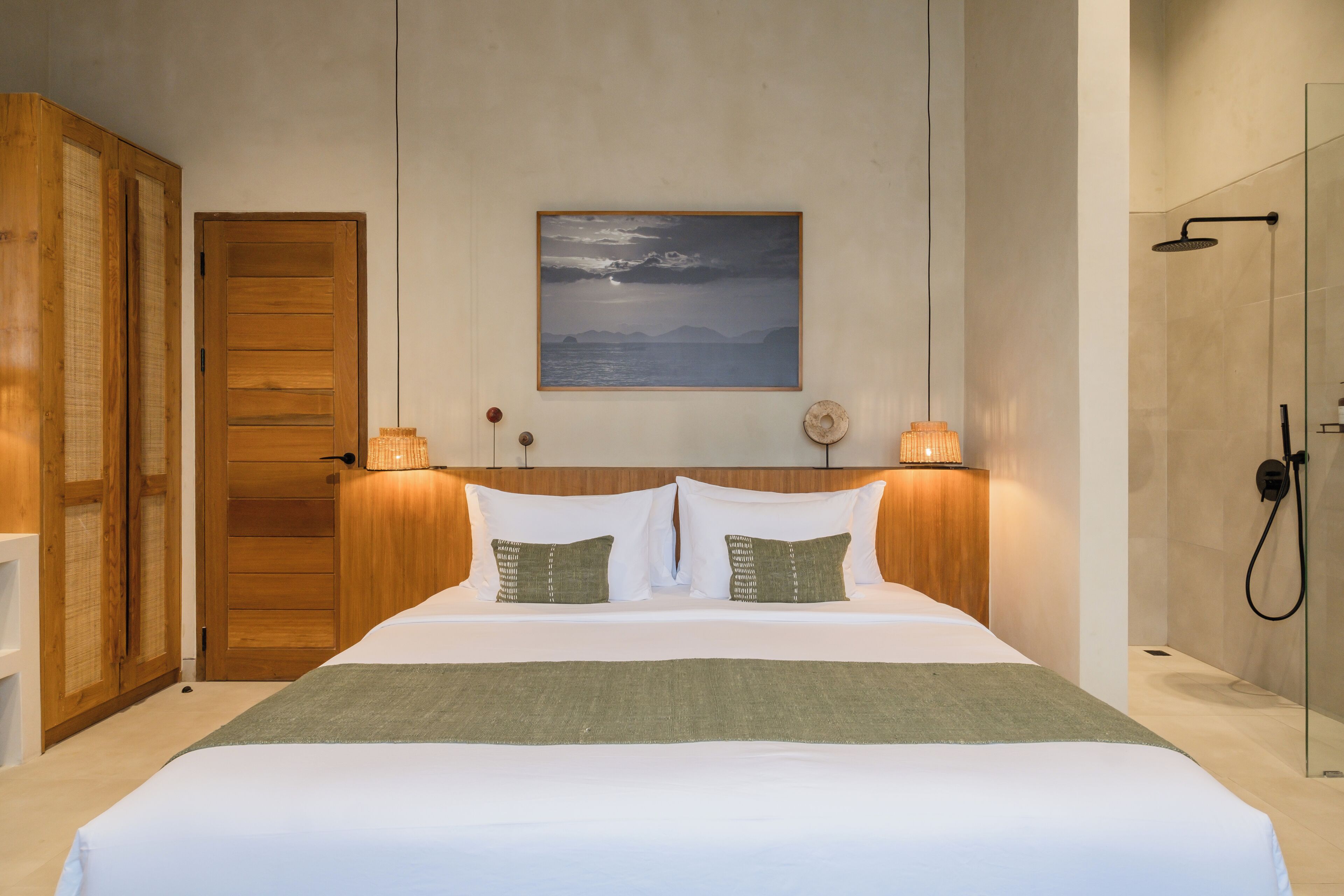 Habitación de hotel con cama, armario de madera, un cuadro en la pared y zona de ducha.