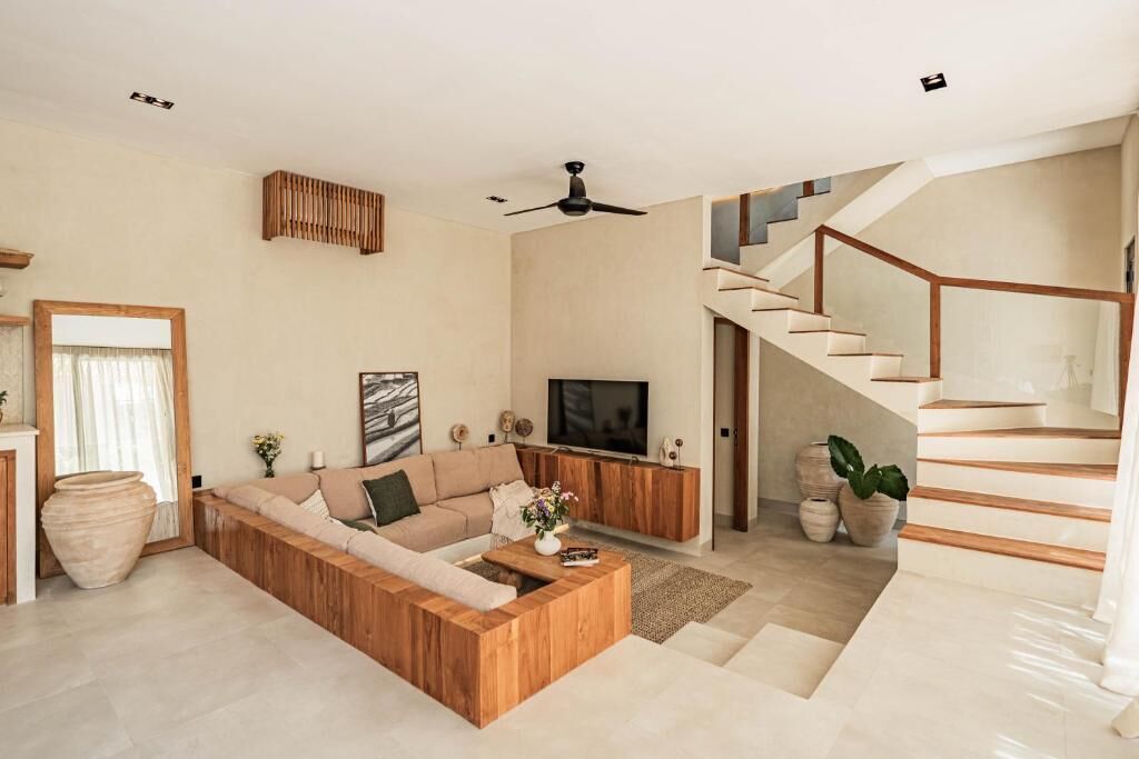 A modern living room with a sectional sofa, a flat-screen TV, and a wooden coffee table.