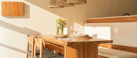 A modern dining area with a wooden table, chairs, and a bench.