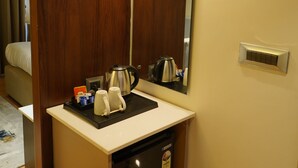 A hotel bathroom with a wooden door, a sink with a mirror, a towel, a trash can, and a wall socket. - Luxe Manor (Kharar)