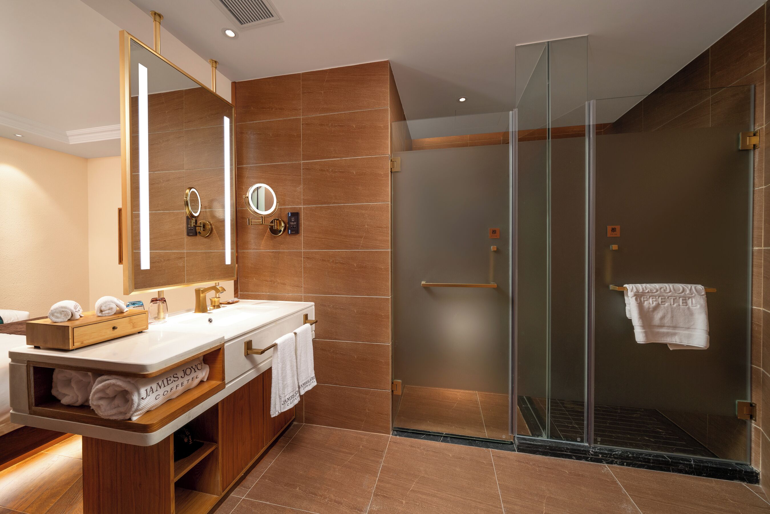 A modern bathroom with a glass-enclosed shower, a vanity with a mirror, and a towel rack.