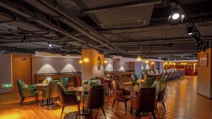 A spacious dining area with multiple tables and chairs, a wooden floor, and industrial-style lighting. - ELITE James Joyce Coffetel Hotel Guangzhou Pedestrian Street Beijing Lu Metro Station Branch - Free Deliver Service to Canton Fair Complex During Canton Fair Period (Guangzhou)