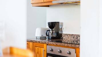Una cocina con armarios de madera, cafetera y tostadora.