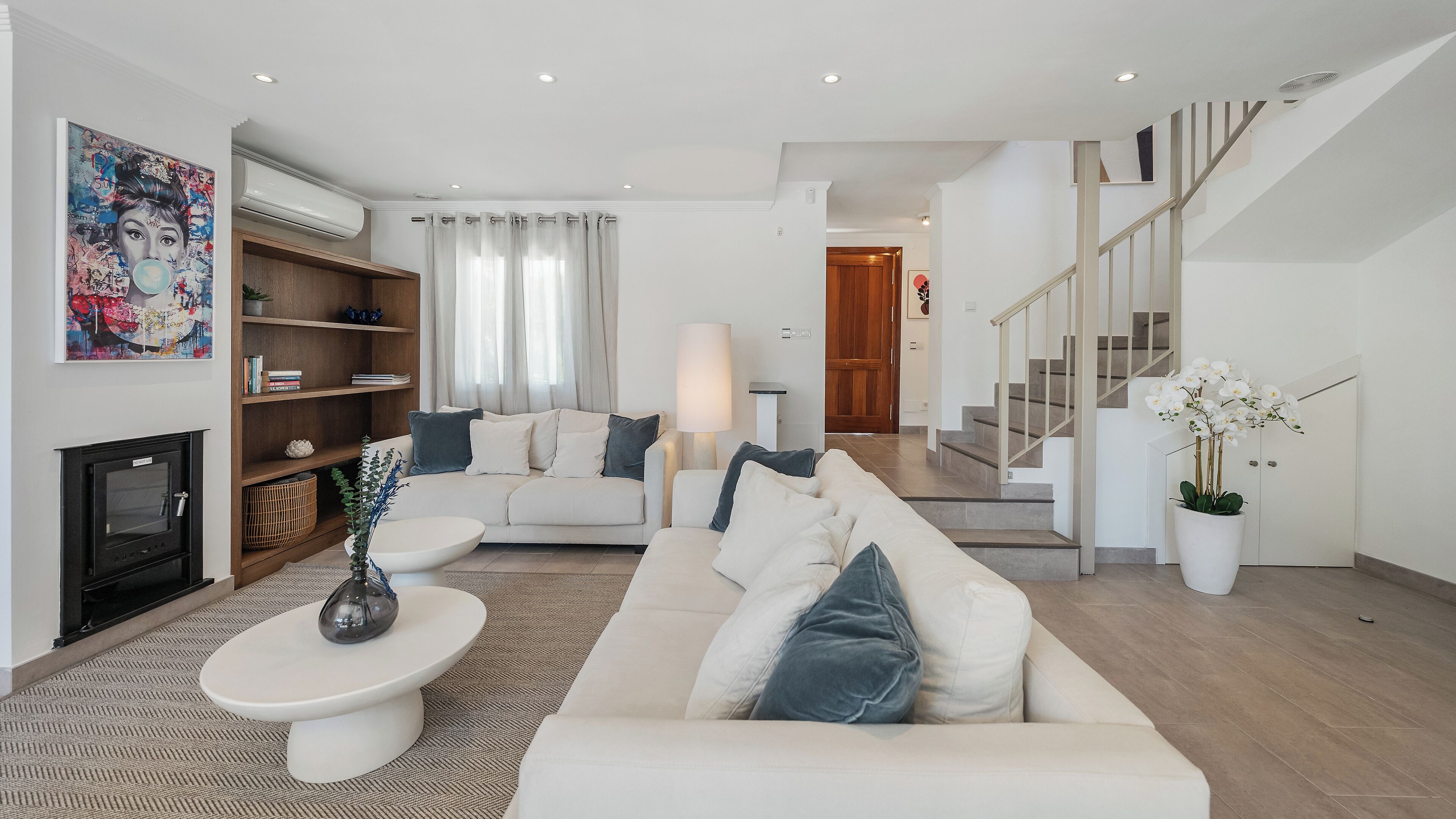 Ein modernes Wohnzimmer mit Sofa, Couchtisch und Kamin.