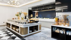A modern kitchen with a buffet setup, a chandelier, and a large window with decorative items. - XANA Deluxe International Hotel Guangzhou East Railway Station Branch - Free Shuttle Bus to Canton Fair Complex During Canton Fair Period (Guangzhou)