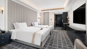 A hotel room with two beds, a TV, a desk, and a bathroom. - XANA Deluxe International Hotel Guangzhou East Railway Station Branch - Free Shuttle Bus to Canton Fair Complex During Canton Fair Period (Guangzhou)