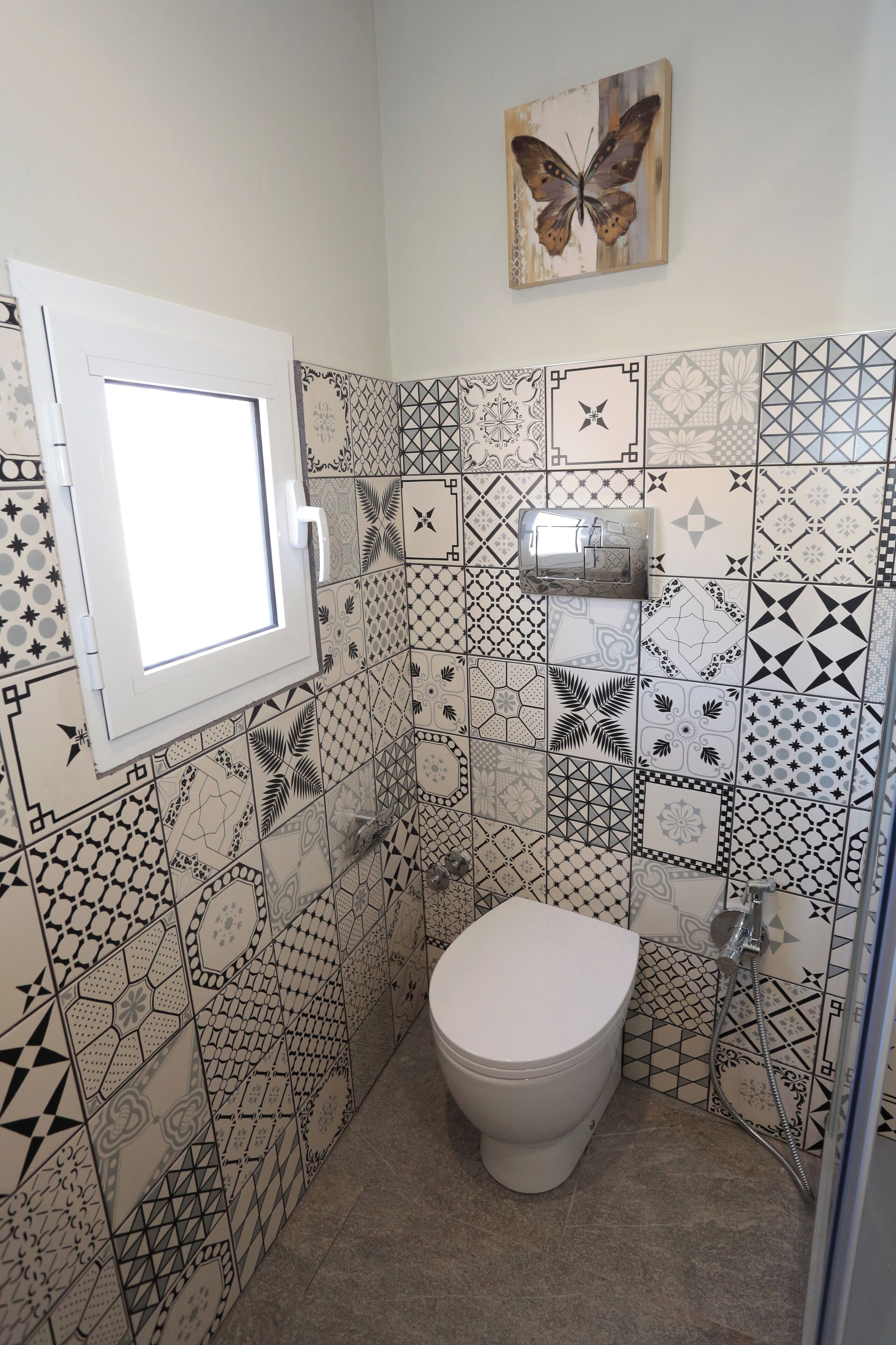 Une salle de bain avec des toilettes, une fenêtre et une douche.