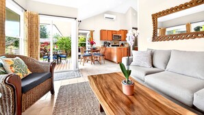 Un salon moderne comprenant un canapé, une table basse et un coin repas avec des chaises et une table.