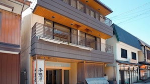 Un bâtiment moderne à deux étages, doté d’une façade en bois, de grandes fenêtres et d’un balcon.
