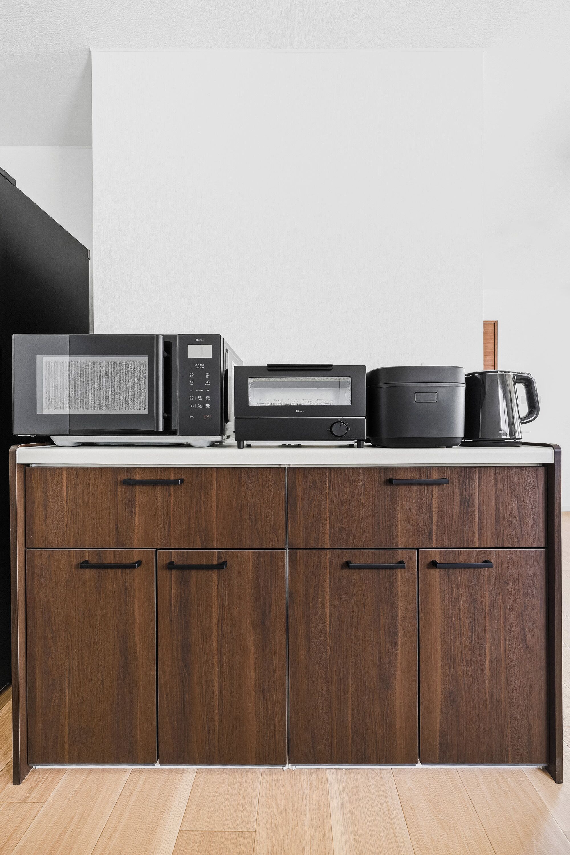 A kitchen with a microwave, toaster, and coffee maker on a countertop.