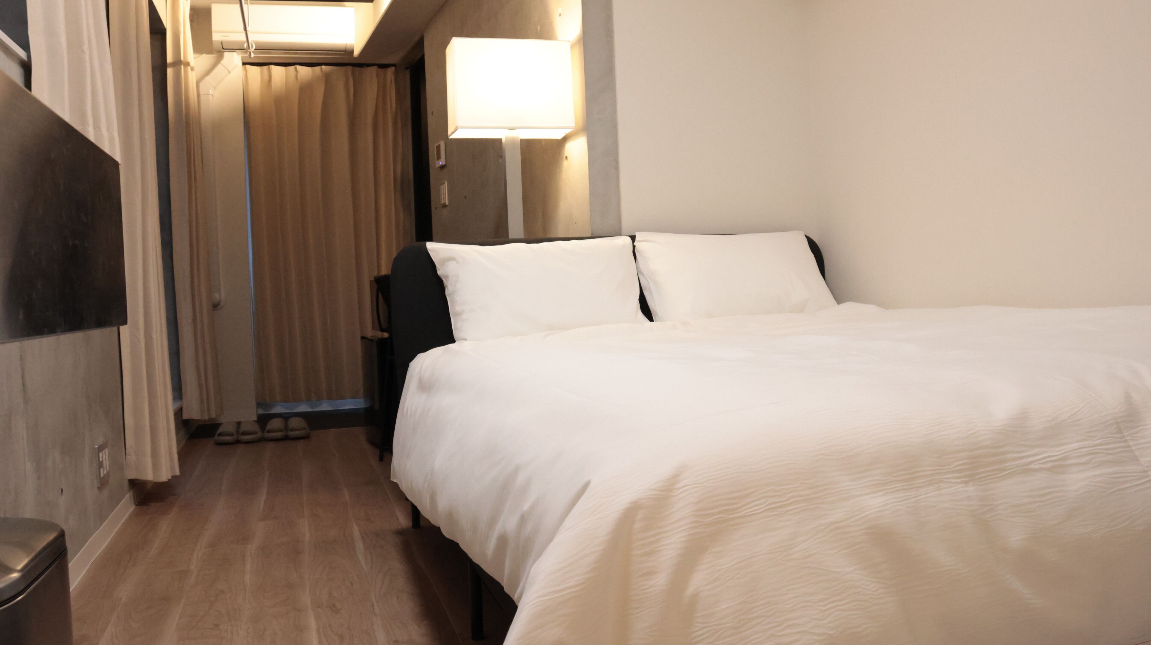Una habitación de hotel con cama, una silla, un escritorio y una ventana.