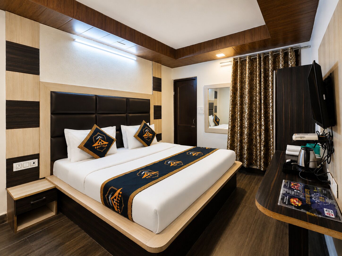 Een hotelkamer met een bed, nachtkastje, televisie en spiegel.
