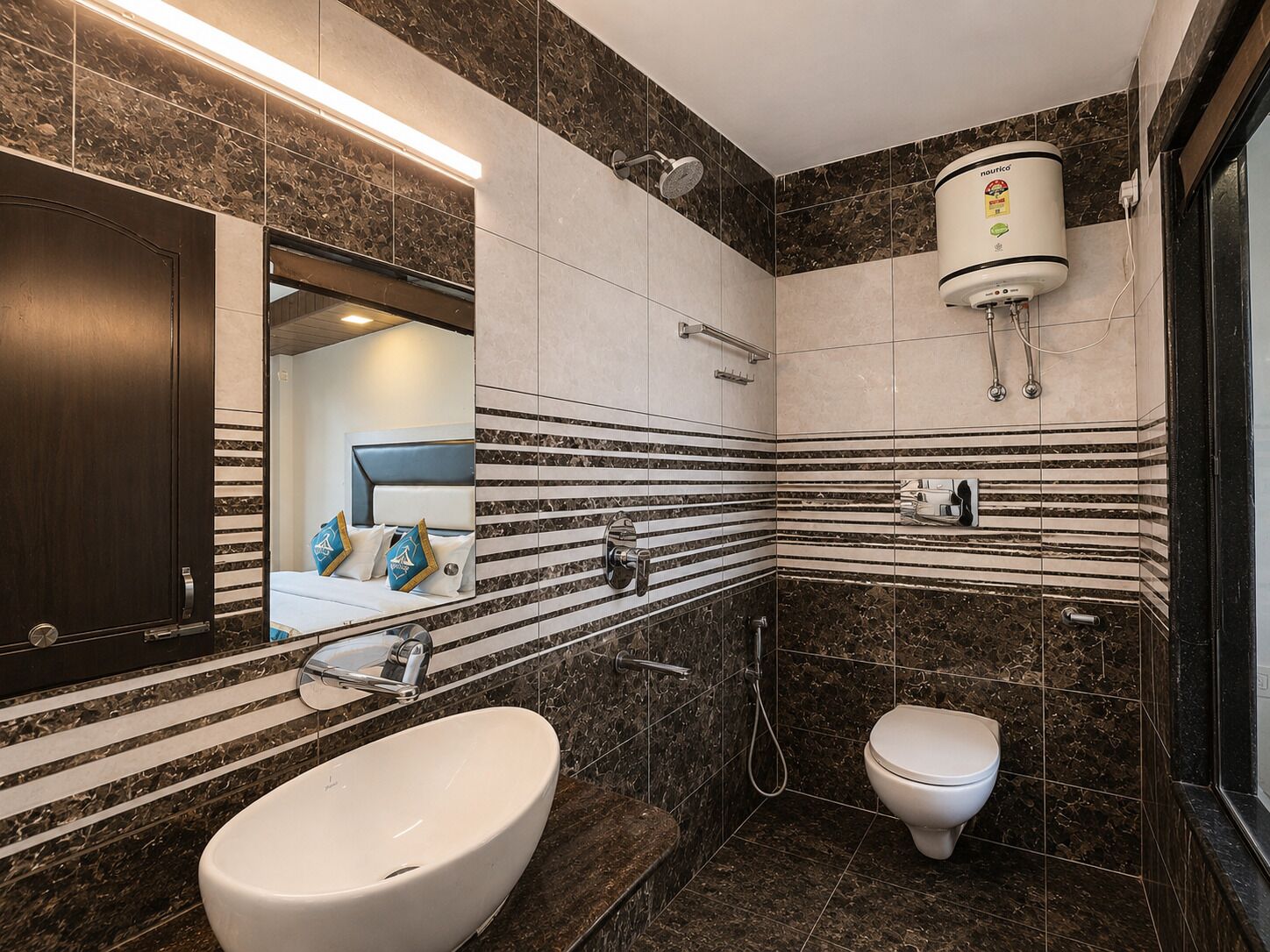 Un baño moderno con un lavamanos ovalado grande, un inodoro, una ducha y un espejo.
