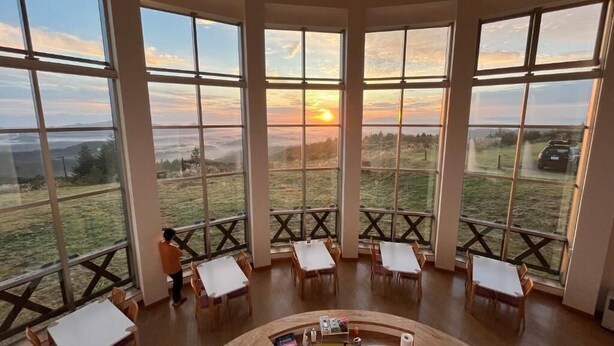 A room with large windows, a central sink, and multiple tables and chairs. - Lodge Cowbell (Takko)