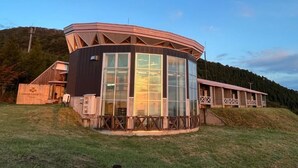 A lodge with a circular structure, large windows, and a wooden deck. - Lodge Cowbell (Takko)