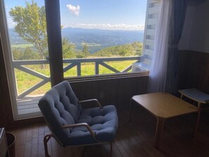 Chambre Triple, balcon, vue montagne | Coin séjour