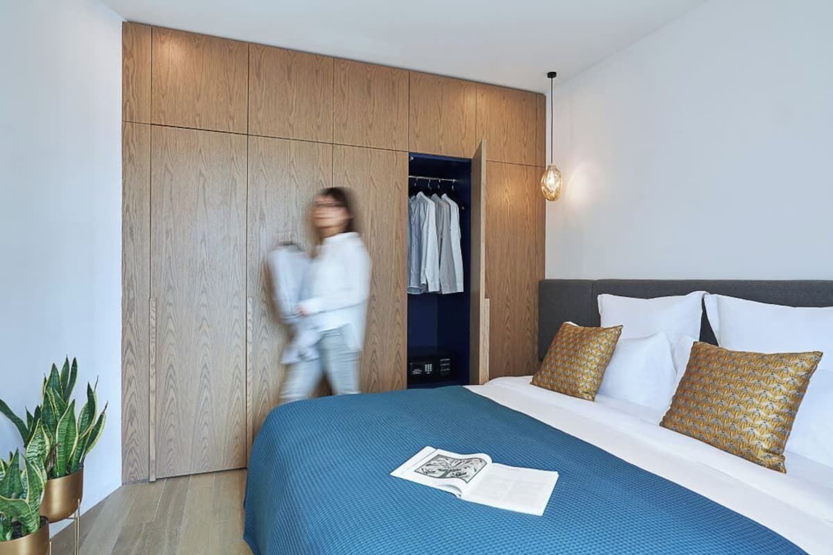 Un dormitorio moderno con una cama grande, un armario y una lámpara colgante.