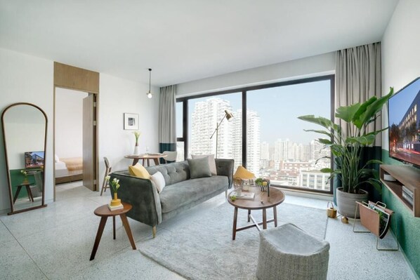 Habitación familiar, varias camas, vista a la ciudad | Área de sala de estar | Televisión 