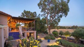 Una casa con patio coperto, arredi esterni e vista sulla campagna.
