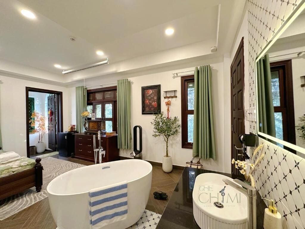 A spacious bathroom with a large bathtub, a separate sink, and a mirror.