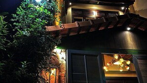 Un edificio de fachada de piedra, con una escalera de madera y un interior iluminado.