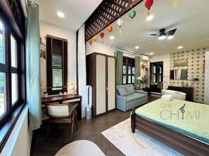 A modern bedroom with a bed, a desk, a chair, a sofa, a bathroom, and a window with blinds. - The ChiMi Homestay & Coffee (TP. Ho Chi Minh)