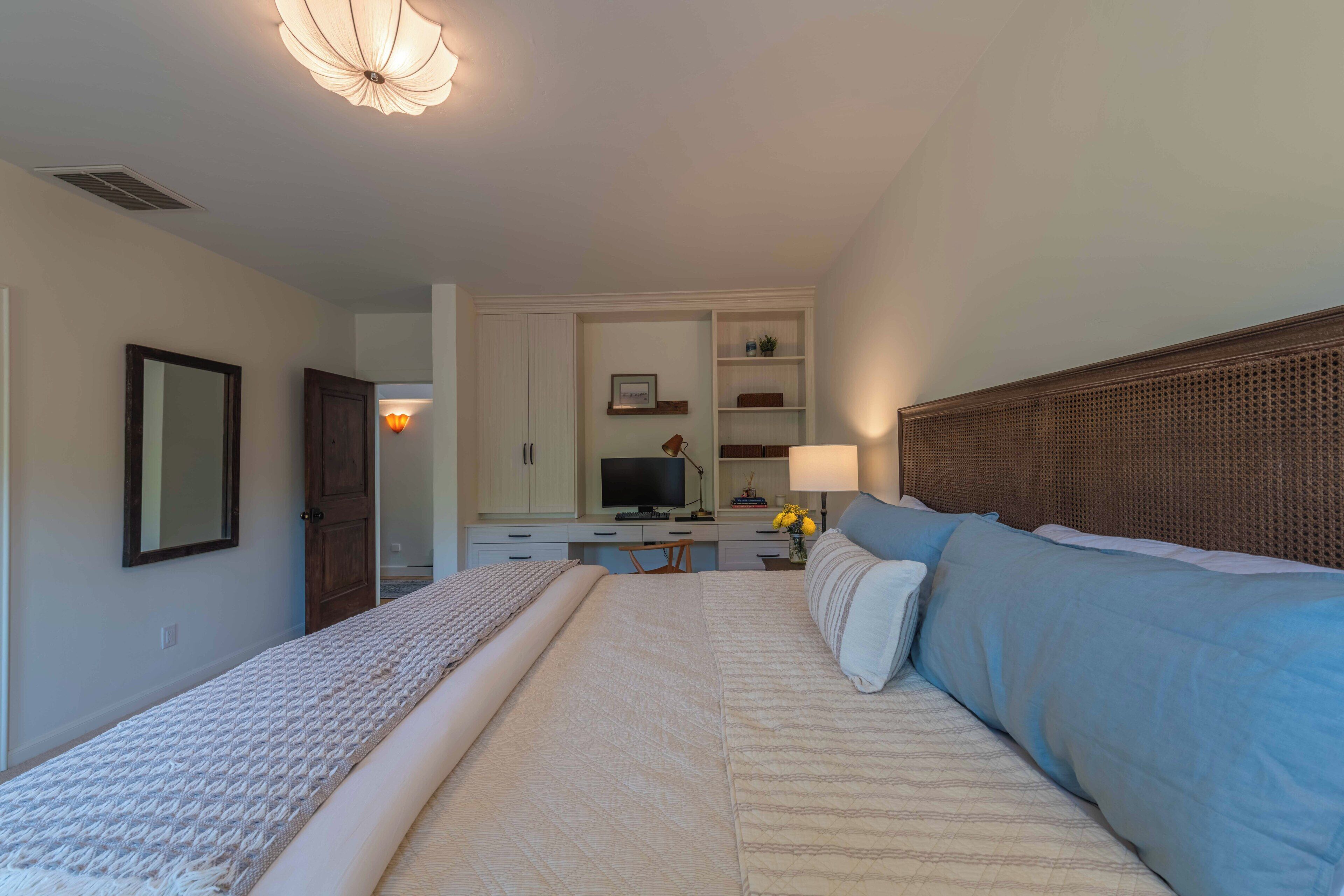 Une chambre d’hôtel avec un grand lit, un bureau avec un ordinateur et une télévision.