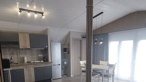 Tilava, moderni keittiö, jossa on ruokailutila, suuret ikkunat ja korkea kattokorkeus.