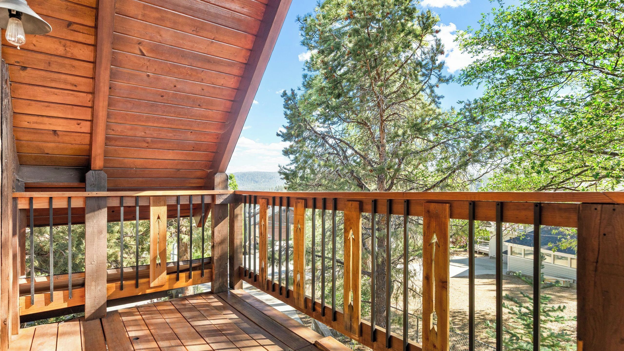 Una terraza de madera con vistas a árboles y montañas.