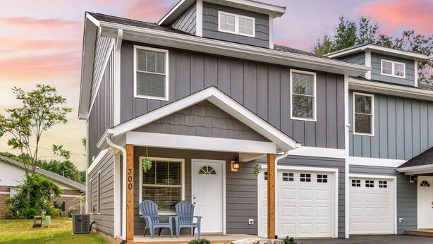 A two-story house with a covered porch, a garage, and a front door. - Red Bud Sycamore by Avantstay Custom Group Retreat w/ Patio (Asheville)