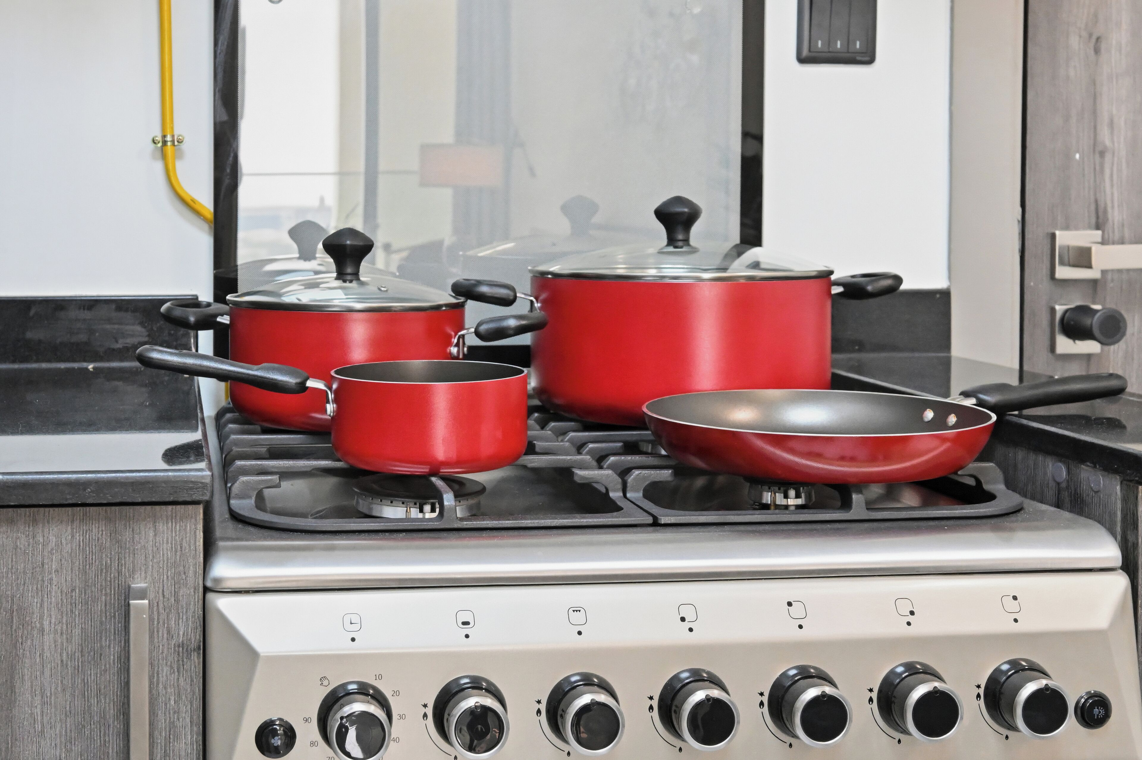 A kitchen with a gas stove, pots, and pans.