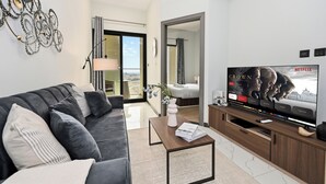 Ein modernes Wohnzimmer mit Sofa, Couchtisch und einem Flachbildfernseher, der eine Netflix-Werbung zeigt.
