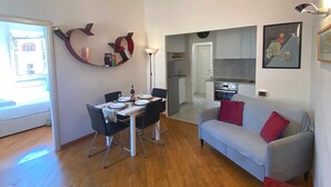 Un salon moderne avec un coin repas, un canapé et une cuisine en arrière-plan.