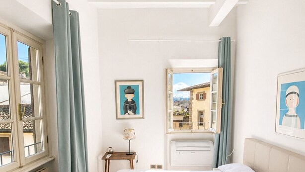 Une chambre à coucher avec un lit, une fenêtre, un radiateur, un bureau et une chaise.